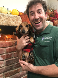 Lead horticulturalist Dan Bangert holds new pet dachshund Oliver